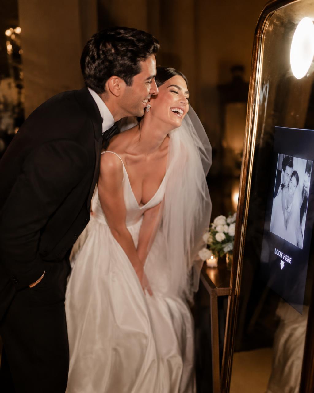 Bride and groom laughing at a mirror photo booth